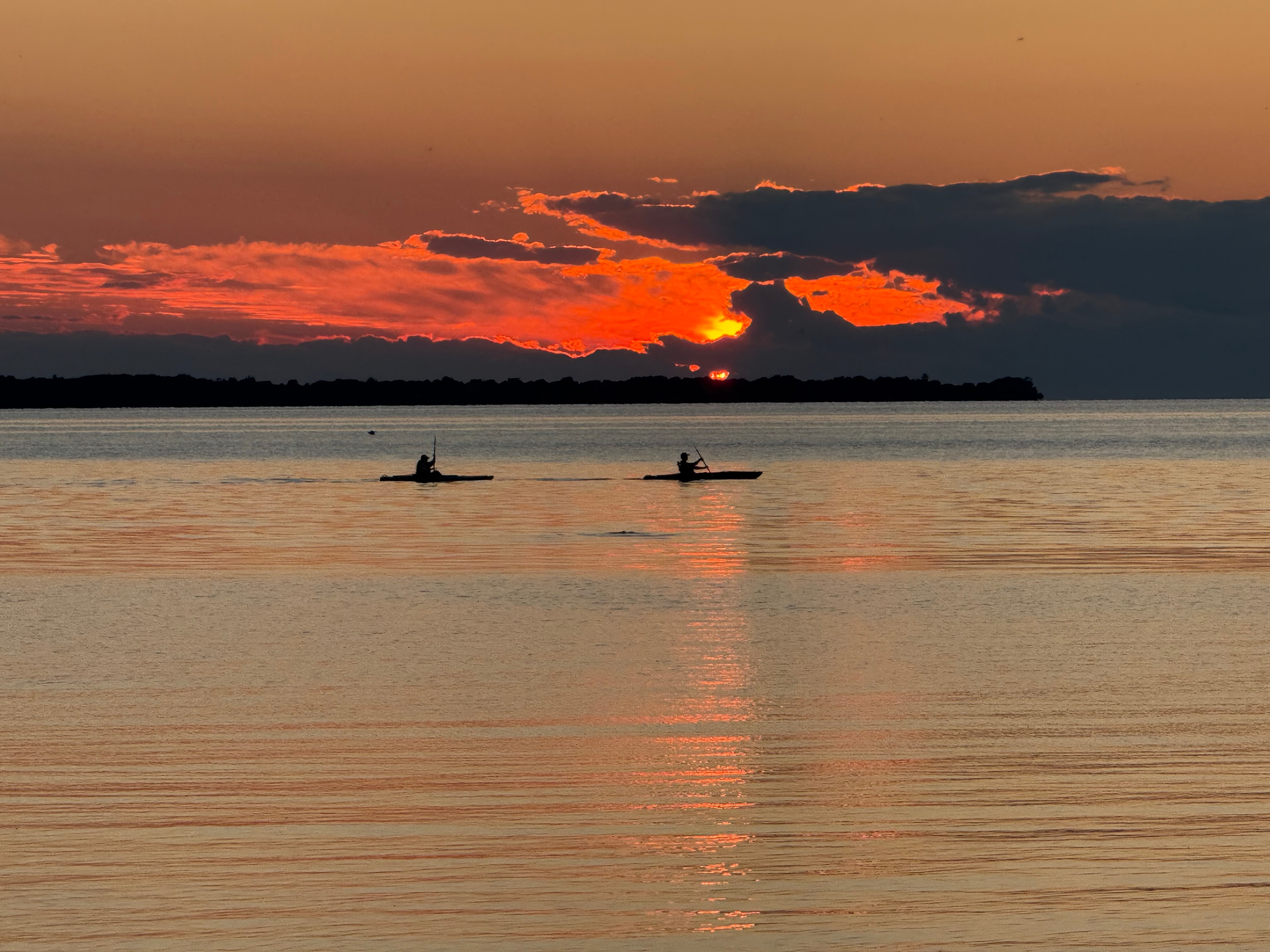 Kayakers Paddling into the Sunset