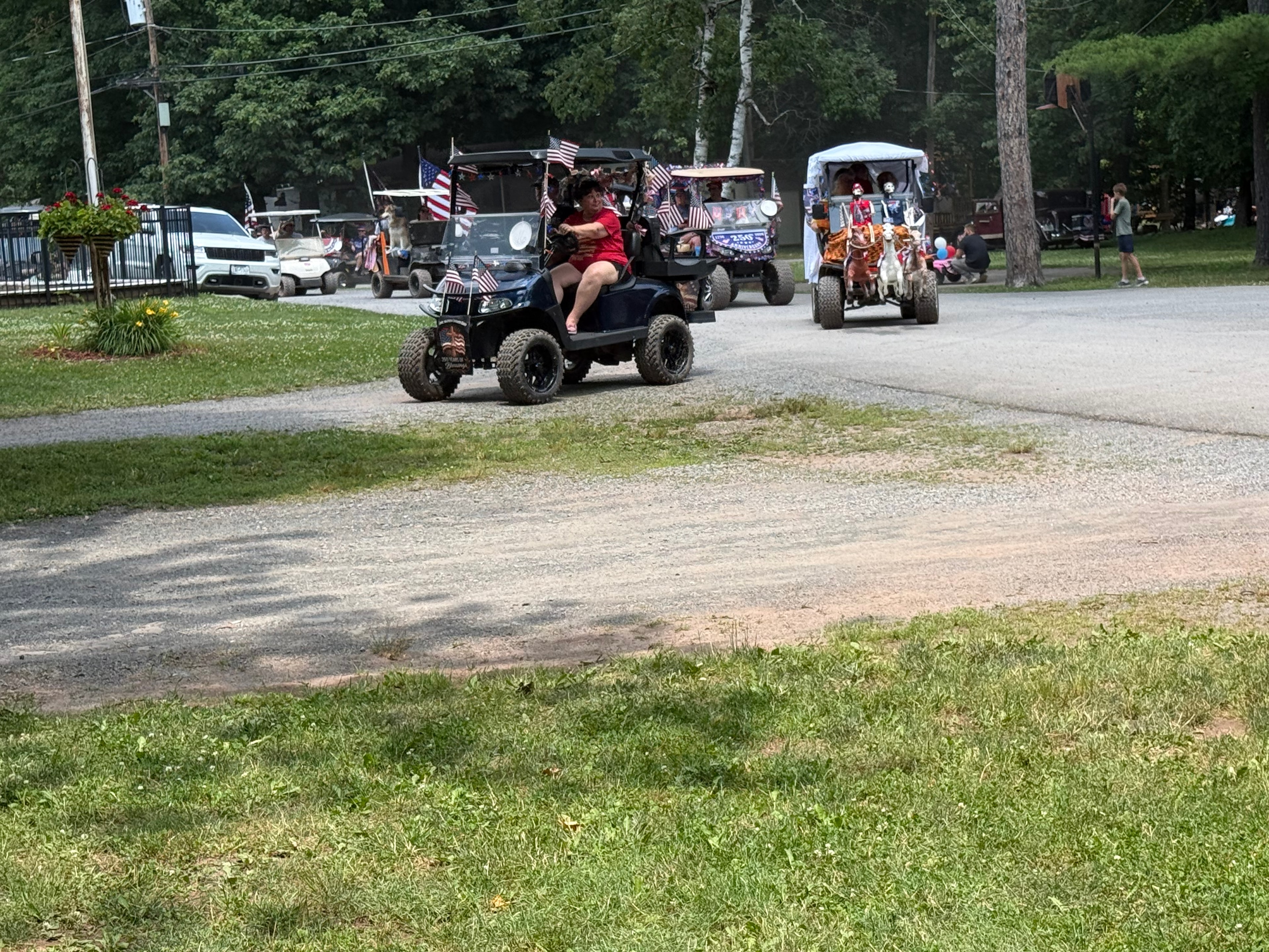 Black cart with American flags leading the parade crowd