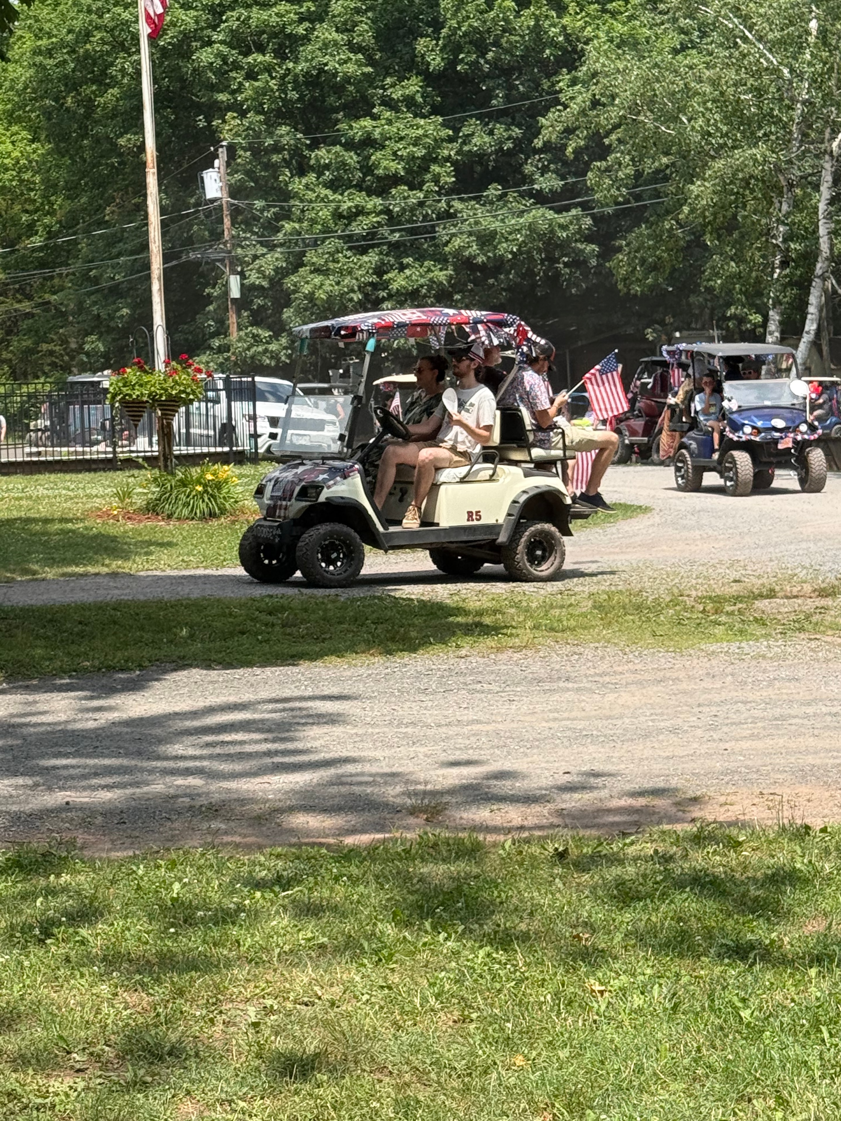 Tan golf cart with American flags in the parade