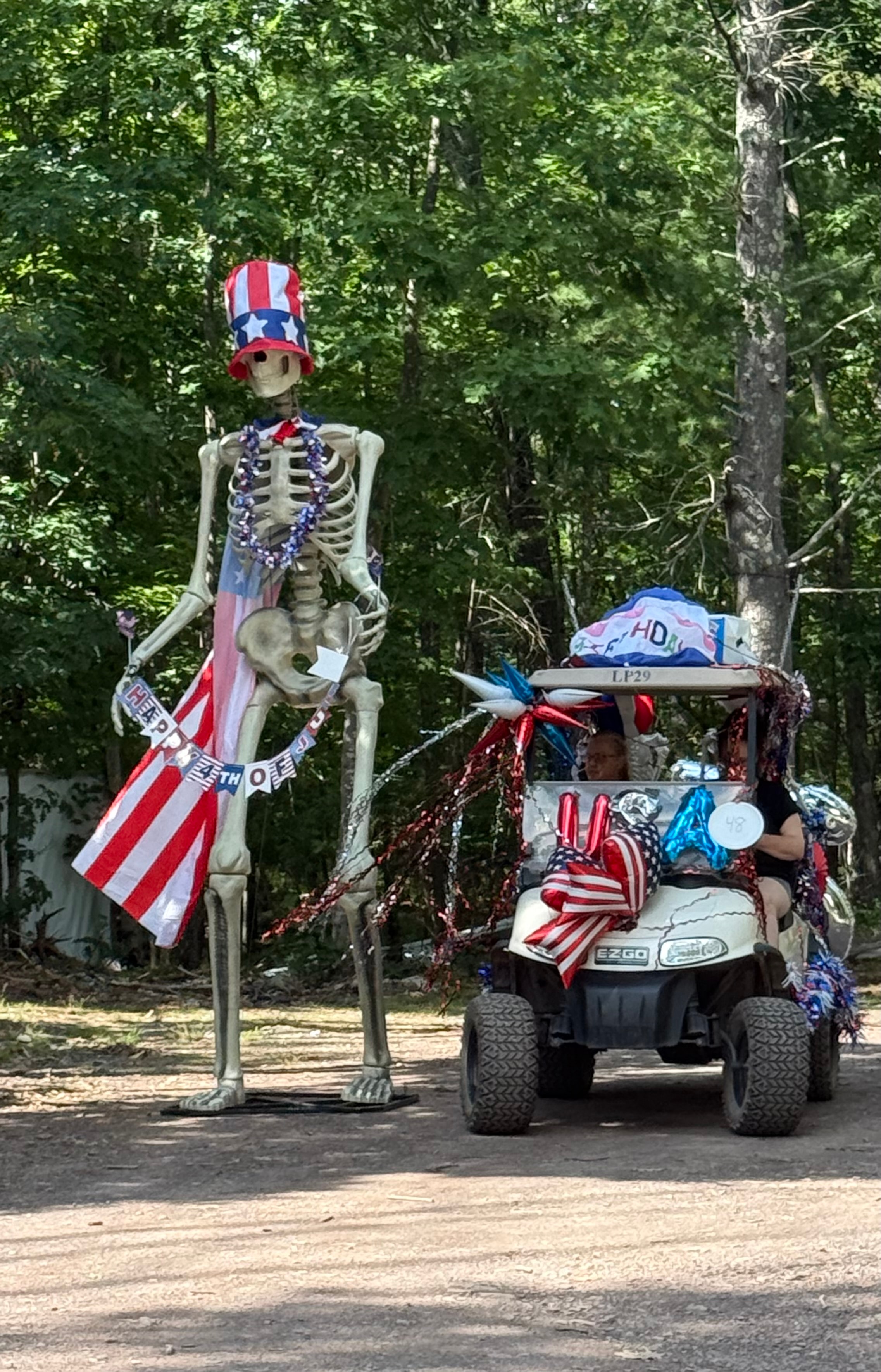 Tall patriotic skeleton with Uncle Sam hat & decorated EZGO golf cart