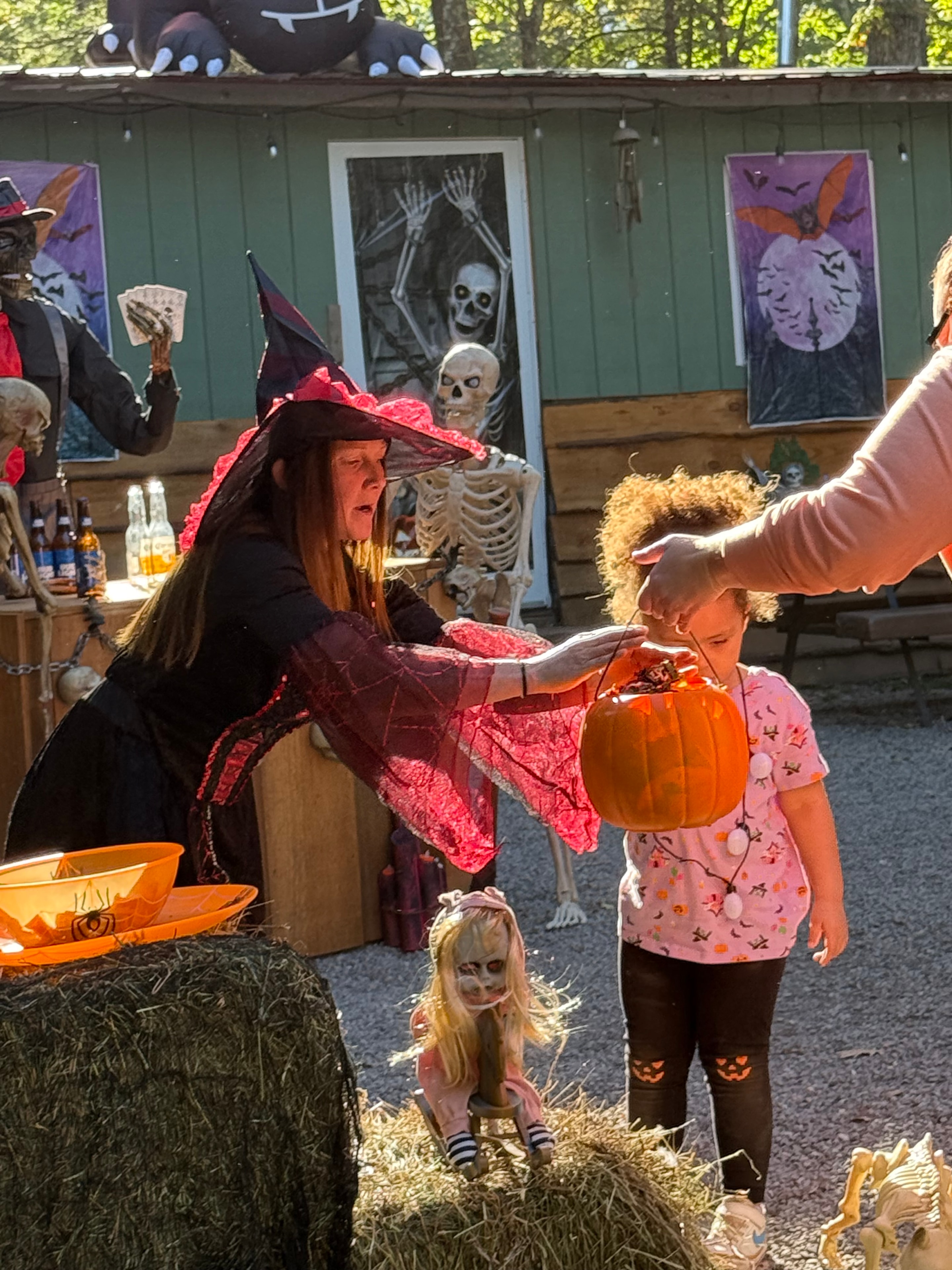 Witch handing out trick or treat pumpkins
