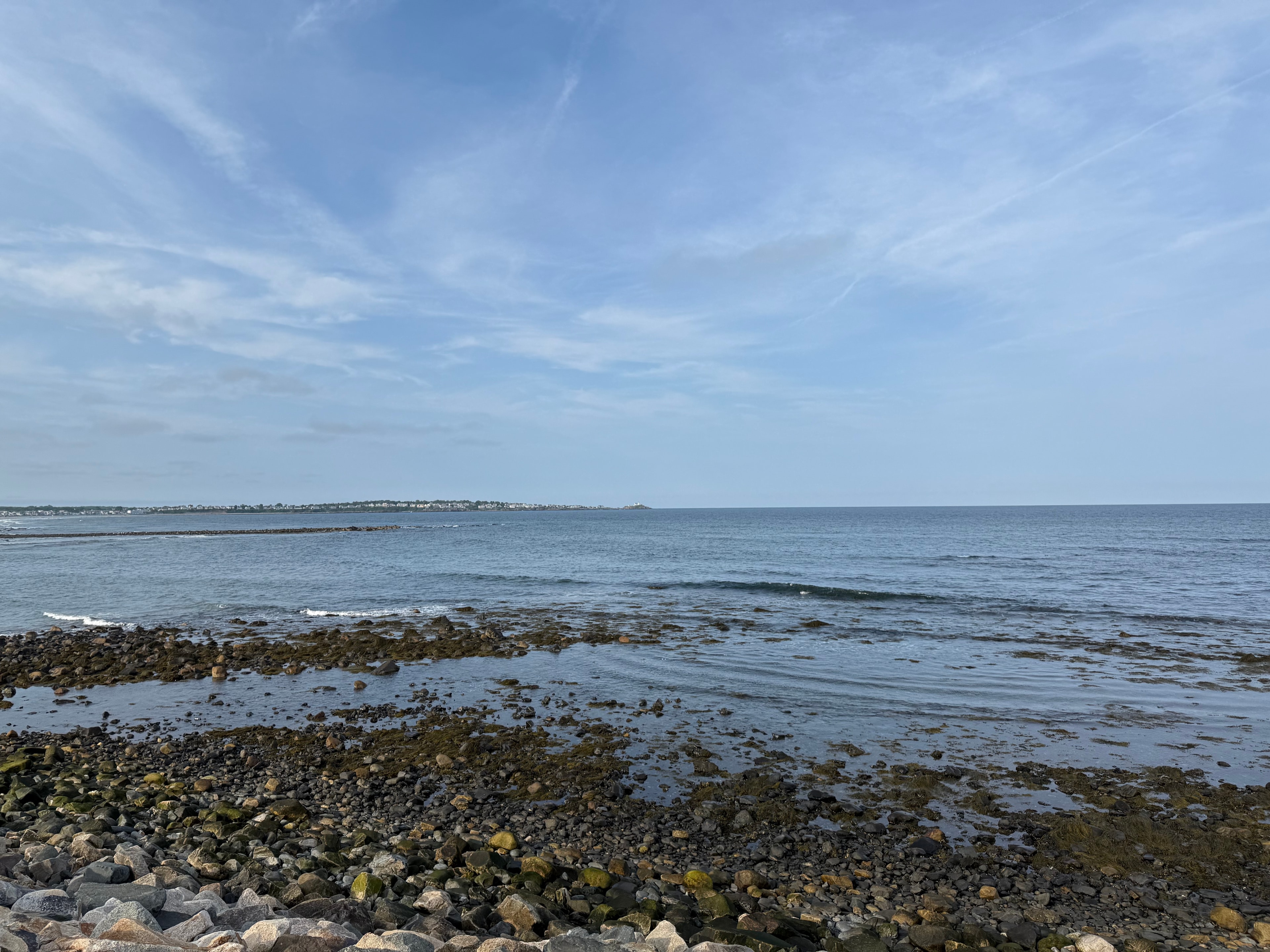 Rocky beach with calm ocean and blue sky